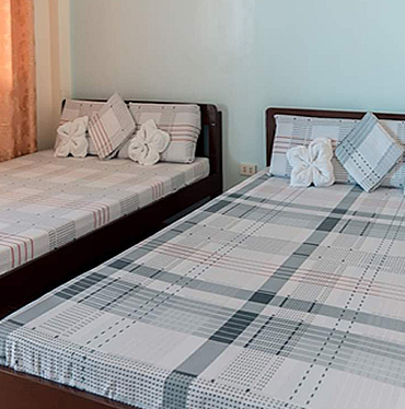 Triple Room, two beds with towel flowers on the pillows